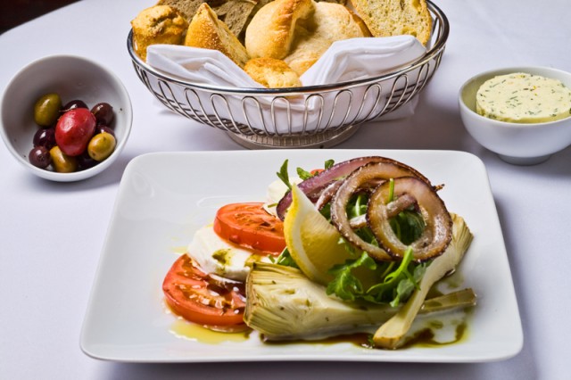 Ensalada de alcachofas, cebollas, rúcula, tomate y queso
